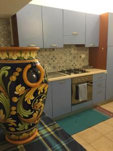 una cucina con un grande vaso sul pavimento di Loft Rapisardi a Catania