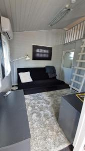 a living room with a black couch in a room at Nalle's in Stavtrup