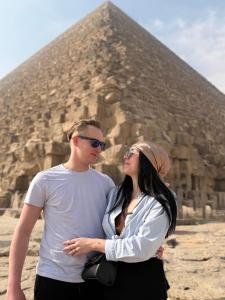a man and a woman standing in front of a pyramid at Infinity Pyramids Inn in Giza