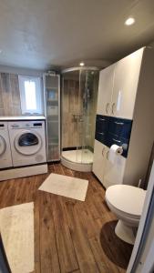 a bathroom with a toilet and a washing machine at Nalle's in Stavtrup +17 photos