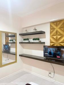 a room with shelves and a tv on a wall at Cozy Studio Condo with Stunning Tagaytay Views in Tagaytay