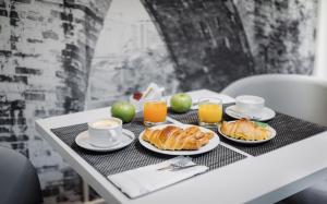 stół ze śniadaniem obejmującym rogaliki i sok pomarańczowy w obiekcie Lisbon Sao Bento Hotel w Lizbonie