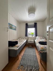 two beds in a small room with a window at Wonderful cottage close to lakes in Södra Rörum