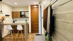 a kitchen with a counter and two stools in a room at Suites Oros in Oaxaca City