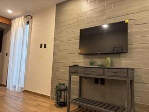 a wall with a flat screen tv on a wall at Suites Oros in Oaxaca City