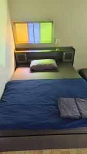 a bedroom with a bed with blue sheets and a window at Thung Setthi Homestay&Cafe4 in Chiang Dao