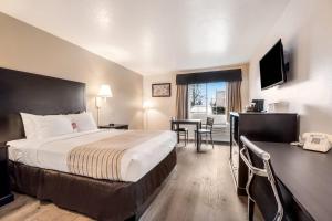 a hotel room with a bed and a table and chairs at Econo Lodge Corvallis Near University in Corvallis