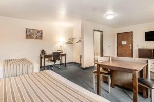 a hotel room with a desk and a bedroom at Econo Lodge Corvallis Near University in Corvallis