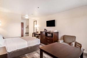 a hotel room with a bed and a table at Econo Lodge Corvallis Near University in Corvallis +21 photos