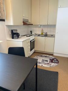 a kitchen with a table and a kitchen rug on the floor at Kangaskartano Yksiö in Keitelepohja