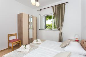 a bedroom with a bed and a window and a chair at Apartments Olive in Mlini
