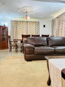 a living room with a leather couch and a table at Aviator Safari bnb in Arusha