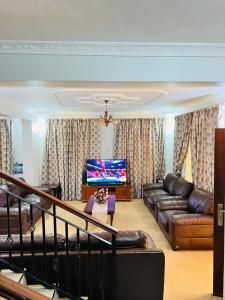 a living room with a couch and a flat screen tv at Aviator Safari bnb in Arusha +1 photo
