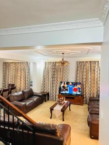 a living room with a couch and a tv at Aviator Safari bnb in Arusha