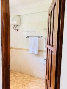 a bathroom with a towel hanging on the wall at Aviator Safari bnb in Arusha