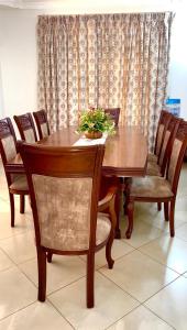 a wooden table and chairs with a plant on it at Aviator Safari bnb in Arusha
