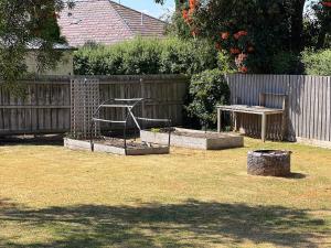 a garden with two raised beds and a wooden fence at Holiday Home in Warrnambool in Warrnambool