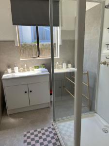 a bathroom with a shower and two sinks and a mirror at Holiday Home in Warrnambool in Warrnambool