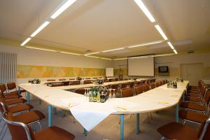 una sala de conferencias con una mesa larga y sillas en Ringhotel Residenz Wittmund en Wittmund