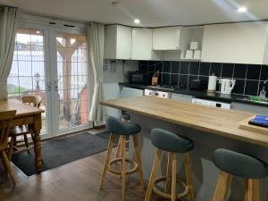 a kitchen with a wooden counter top and a table at fairfeilds cottage Frog Trotters Bottom in Hartpury
