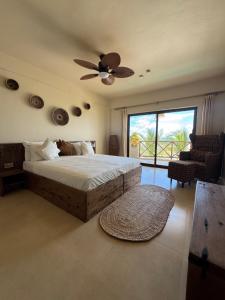 a bedroom with a bed and a ceiling fan at Tangawizi Lodge Zanzibar - Adults Only in Jambiani