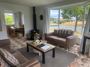 a living room with a couch and a coffee table at Cosy & close to town in Te Anau