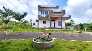 a house with a garden in front of it at 'Tatvamasi' Farmstay, Hillock The Nature Retreat, Vikarabad in Morangpalli