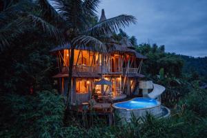 a tree house with a pool in front of it at Jiva Bali - Inaya in Selat