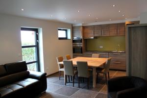 a kitchen with a wooden table and chairs at De Maalderie Holiday Home in Houthulst