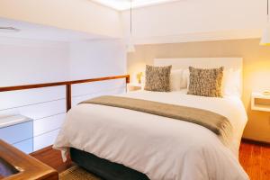 a bedroom with a large white bed with pillows at Cape Diem Lodge in Cape Town +78 photos