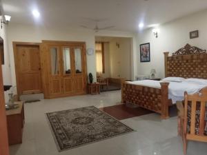 a bedroom with a bed and a room with a rug at Gahirat Castle Chitral in Chitral