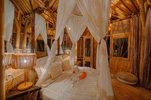 a bedroom with a canopy bed with white drapes at Jiva Bali - Inaya in Selat