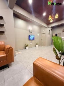 a lobby with a waiting room with a couch and a tv at Nvoyages Wayanad in Wayanad