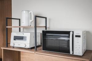 a microwave and a toaster oven on a shelf at Villa Mimosa Myoko in Myoko
