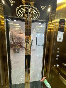 a man standing in a mirror in a elevator at Honeybee Villa in Văn Lâm