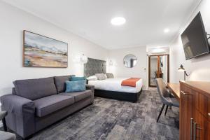a hotel room with a couch and a bed at Comfort Inn Deakin Palms in Mildura