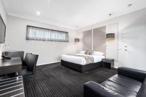 a hotel room with a bed and a couch at Comfort Inn Deakin Palms in Mildura +93 photos