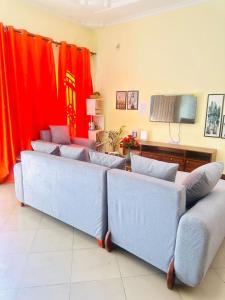 a group of couches in a living room with red curtains at The Hidden Gem Near Central B&B in Nkunjila