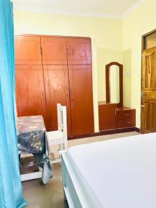 a bedroom with a bed and wooden cabinets at The Hidden Gem Near Central B&B in Nkunjila