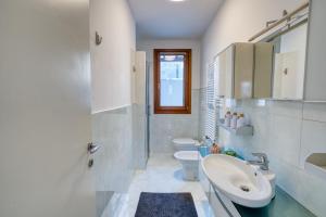a white bathroom with two toilets and a sink at Casa Altea in Pordenone
