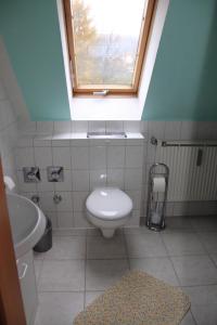 ein Bad mit einem WC und einem Fenster in der Unterkunft Ferienwohnung Krug in Sassnitz
