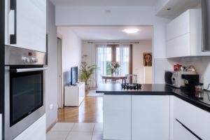 a kitchen with white cabinets and black counter tops at Casa Altea in Pordenone +5 photos