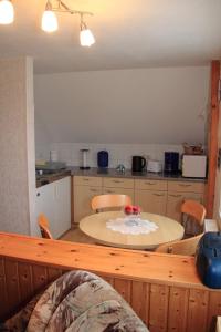 eine Küche mit einem Tisch und eine Küche mit einem Tisch und Stühlen in der Unterkunft Ferienwohnung Krug in Sassnitz