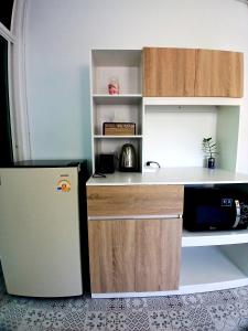 a small kitchen with a refrigerator and a counter at Baan Cozy Boutique Natural Wellness Chiang Mai in Chiang Mai