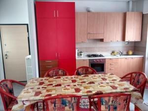 a kitchen with a table with chairs and red cabinets at Gardens House in Varenna