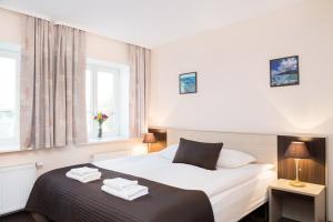 ein Schlafzimmer mit einem Bett, auf dem zwei Handtücher liegen in der Unterkunft Ivolita Vilnius in Vilnius