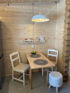 Ein Holztisch und Stühle in einer Küche mit Licht in der Unterkunft Zwinger in Pilipets