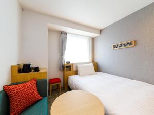 a room with two beds and a table and a chair at Comfort Hotel Kii Tanabe in Tanabe