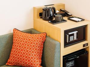 a microwave sitting next to a couch with a pillow at Comfort Hotel Kii Tanabe in Tanabe