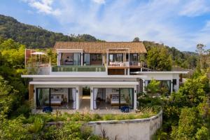 an aerial view of a house with mountains in the background at Pahili Pool Villas Koh Phangan in Mae Haad